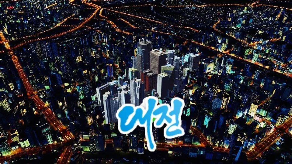 밤의 대도시를 높은 곳에서 내려다본 화면. 주황색 가로등이 격자로 뻗고 푸른 고층 건물들이 빛난다. 가운데에 하늘색 붓글씨체로 '대전'이 얹혀 있다.